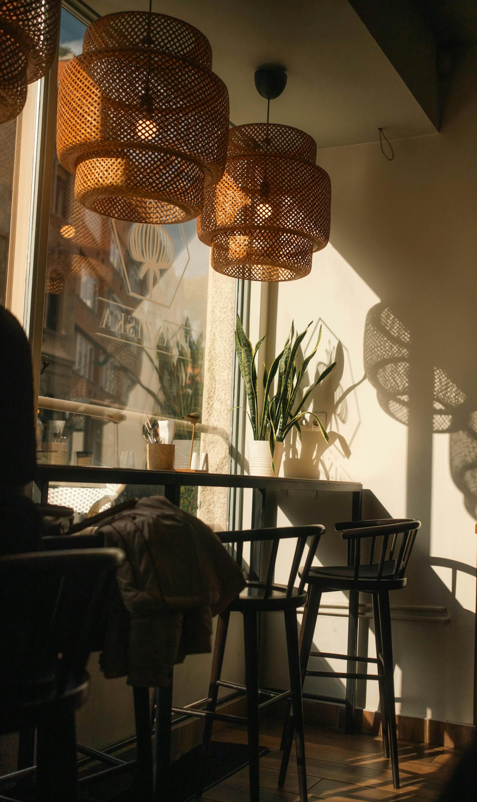 Serene interior corner with rattan pendant lamps and warm afternoon light.
